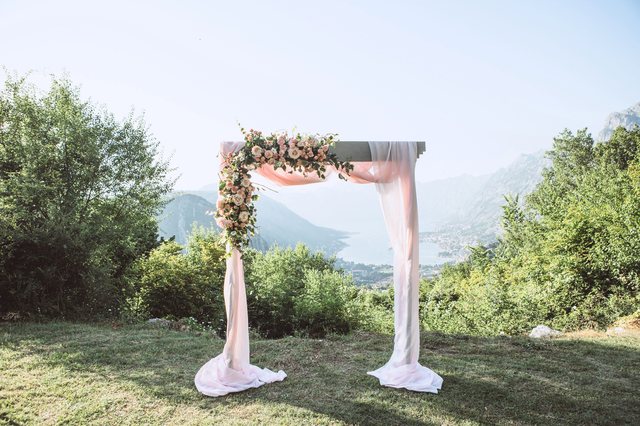Draped floral wedding arch set up outdoors