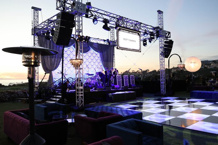 Illuminated dance floor with staging and lighting truss at dusk